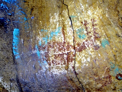 Arte rupestre daado con pintura de color azul verdoso. 